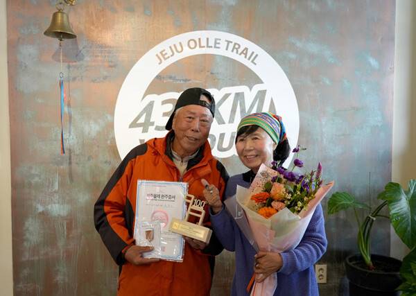 100회 완주자 한창수씨(왼쪽)와 사단법인 제주올레 서명숙 이사장.(사)제주올레 제공.