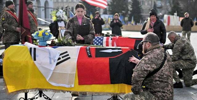 우크라이나 군인들이 25일(현지시각) 키이우 독립광장에서 도네츠크 전선에서 전사한 한국인 김 아무개씨의 관에 예우를 표하고 있다. 키이우/AFP 연합뉴스
