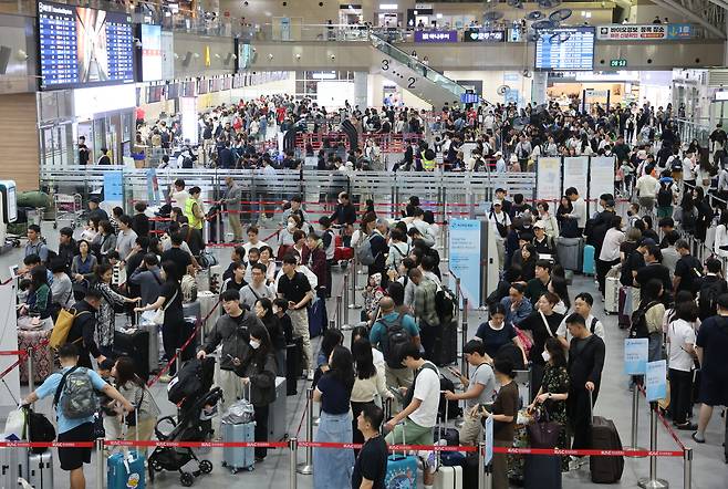Travelers heading overseas during the Chuseok holiday wait in long lines at the international departures hall of Gimhae International Airport in Gangseo District, Busan, on the morning of Oct. 2. The airport, which handles domestic flights and short-haul routes across Asia, has long been criticized for its limited and outdated facilities. [YONHAP]