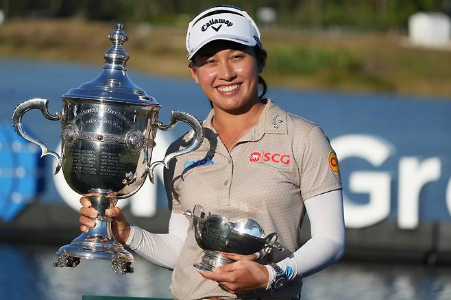 Jeeno Thitikul holds the Bear Trophy and the Rolex Player of the Year Trophy at Tiburon Golf Club in Naples, Florida on Nov. 23. [AP/YONHAP]