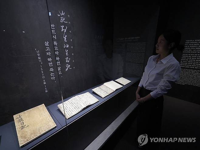 이순신이 임진왜란 중 쓴 일기 '난중일기' (서울=연합뉴스) 강민지 기자 = 27일 서울 용산구 국립중앙박물관에서 '우리들의 이순신' 전시 언론공개회에서 참석자가 '난중일기' 친필본 등을 둘러보고 있다. 충무공 탄신 480주년과 광복 80주년을 맞아 선보이는 전시는 다음 달 4일까지는 무료 개방한다. 2025.11.27  mjkang@yna.co.kr