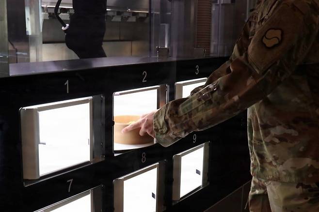 최근 대구 미군기지에 문을 연 로봇취사식당에서 장병이 주문한 음식을 꺼내고 있다./미 육군