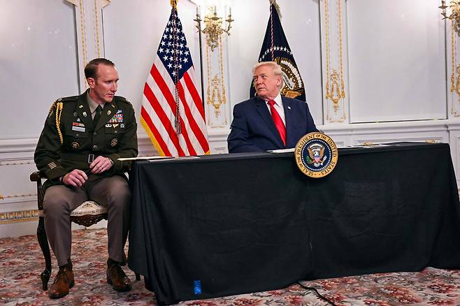 도널드 트럼프 미국 대통령(오른쪽)이 2025년 11월 27일 추수감사절 연휴 동안 플로리다주 팜비치에 있는 자신의 마라라고 별장에서 장병들과 화상 통화를 하는 동시에 찰리 록우드 미 육군 중령과 이야기를 나누고 있다. /연합뉴스