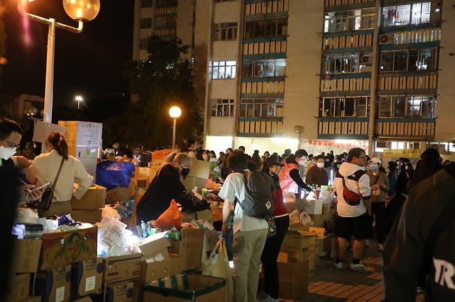 화재 발생한 '웡 푹 코트'(Wang Fuk Court) 인근에 모인 자원봉사자들 27일 오후 11시께 홍콩 북부 타이포의 고층 아파트 단지 '웡푹 코트'(Wang Fuk Court) 인근에서 자원봉사자들이 구호 물품을 나눠주는 모습.[촬영 박수현]