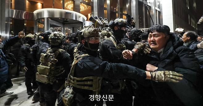 윤석열 대통령이 비상계엄을 선포한 후 자정을 넘긴 지난해 12월 4일 새벽 국회의사당에 도착한 무장군인들이 국회 본청 진입을 시도하자 국회 직원 등이 격렬히 막아서고 있다. 성동훈 기자