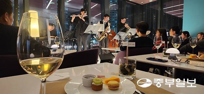 코트야드 메리어트 수원이 지난 28일 오후 수원 키친 2층에서 진행한 '재즈룸 프라이데이' 행사에서 이용객들이 곡과 어울리게 페어링 제공된 와인을 마시며 재즈 공연을 감상하고 있다. 신연경기자