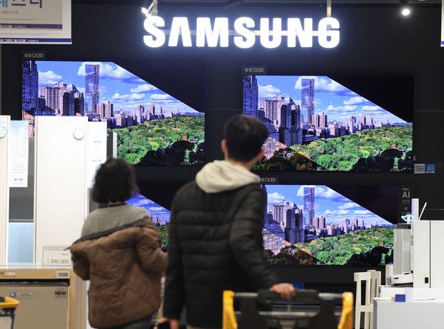 삼성전자의 20년 연속 세계 TV 시장 매출 점유율 1위 수성이 유력한 가운데, 30일 행인들이 서울시내 한 가전제품 매장에서 삼성전자 TV를 살펴보고 있다. 연합뉴스