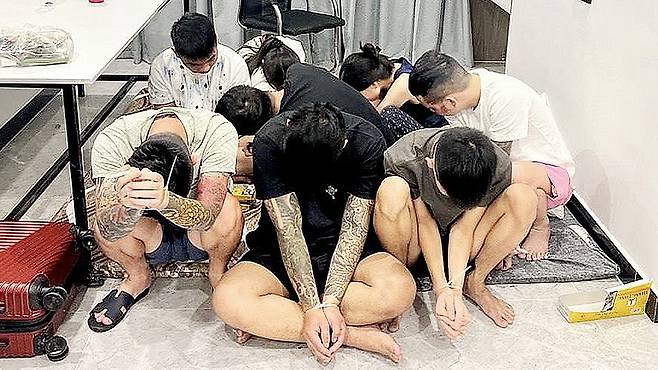 Suspects are seen with their hands zip-tied after being detained during a police raid on a scam center in Phnom Penh, Cambodia, on July 16.  [EPA/YONHAP]