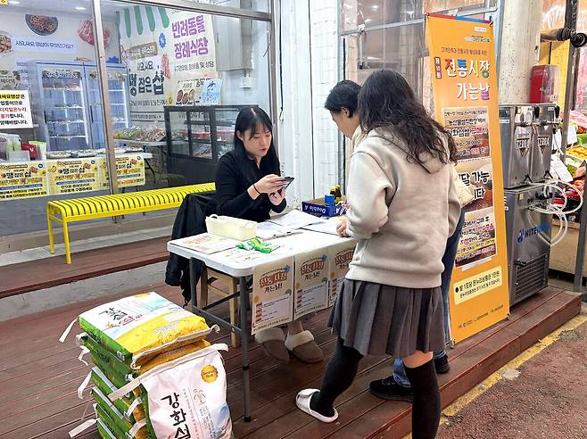 ▲ 강남시장에 마련된 공유형 세일 매대 '땡샵' 앞에서 전통시장 가는 날 행사가 진행되고 있다. /사진제공=강남시장 상인회