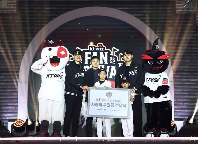 수원컨벤션센터에서 개최된 ‘2025 kt wiz 팬 페스티벌’ 사랑의 후원금 전달식에서 좌측부터 고영표 kt wiz 선수, 이정호 KT알파 쇼핑 부문장, 베스트원야구단 대표 학생들, 소형준 kt wiz 선수가 기념 촬영을 하고 있다. KT알파 쇼핑 제공