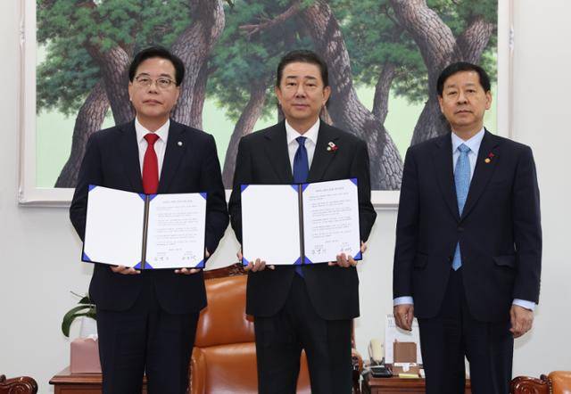 송언석(왼쪽) 국민의힘 원내대표와 김병기(가운데) 더불어민주당 원내대표가 2일 국회에서 2026년도 예산안 처리를 위한 합의문에 서명한 뒤 구윤철 부총리 겸 기획재정부 장관과 함께 기념 촬영을 하고 있다. 민경석 기자