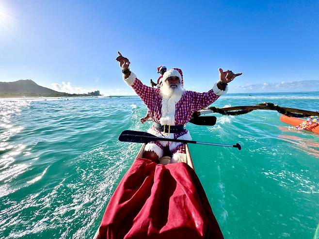 하와이 산타 할아버지가 신났다. 하와이 아웃리거 와이키키 산타 카누행사는 20년 전통을 가지고 있다.[아웃리거 와이키키 제공]