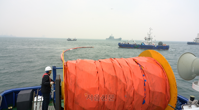 해양환경공단 방제선이 대규모 유류 확산에 따른 해상오염을 막기 위해 오일펜스를 설치하고 있다.