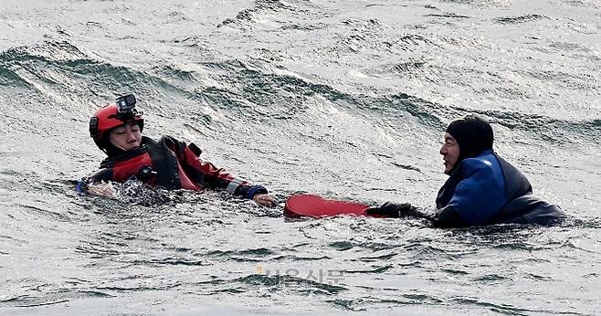 인천해경 대원이 부표를 이용해 표류자를 구조하고 있다.