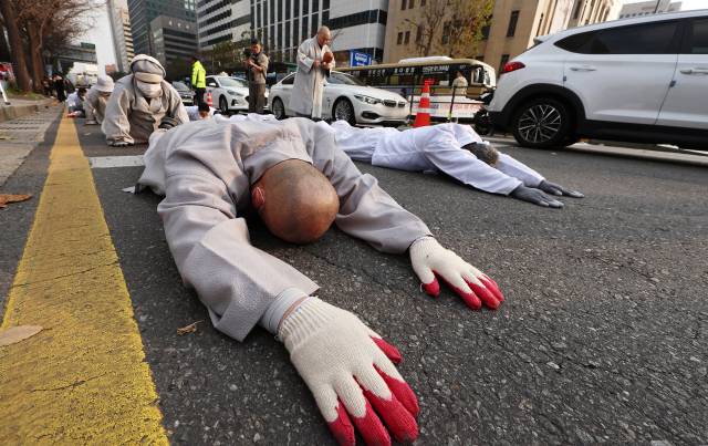 조계종사회노동위원회 관계자들이 지난달 30일 서울 광화문 일대에서 대구의 한 자동차부품 제조공장에서 숨진 베트남 국적 뚜안 씨 사망사건 진상규명과 이주노동자 강제단속 중단을 촉구하는 오체투지를 하고 있다. 연합뉴스