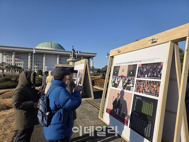 3일 오후 3시쯤 국회 중앙잔디광장에서 열린 사진전을 감상하고 있는 시민들의 모습이다. (사진=염정인 기자)
