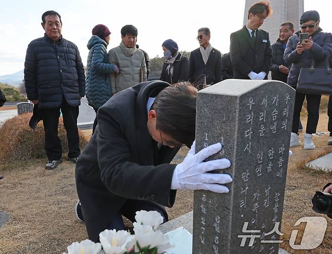 12·3 불법 비상계엄 1년이 된 3일 조경태 국민의힘 의원이 광주 북구 운정동 국립 5·18민주묘지 문재학 열사 묘역에서 무릎 꿇은 채 기도하고 있다. 2025.12.3/뉴스1 ⓒ News1 박지현 기자