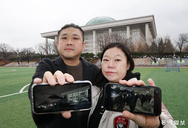 12·3 계엄 당시 “구금될 수도 있다”는 생각에 일주일 치 당뇨약(인슐린)까지 챙겨 국회로 향했던 방희준(48) 김원경 씨(44) 부부가 지난달 27일 국회운동장에서 당시 촬영한 사진을 보여주고 있다. 김 씨는 “서로 모르는 시민들이 말없이 돕는 모습을 보며 ‘우리는 언제든 다시 힘을 합칠 수 있다’는 희망을 봤다”고 했다. 방 씨는 “계엄 이후 시민들이 정치가 운전대를 제대로 잡고 있는지 감시해야 한다는 걸 깨닫게 된 것 같다”고 말했다. 이훈구 기자 ufo@donga.com