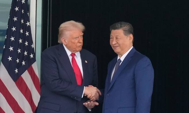 도널드 트럼프 미국 대통령(왼쪽)과 시진핑 중국 국가주석이 1030일 김해공군기지 나래마루에서 미-중 정상회담을 앞두고 악수하고 있다. AP 연합뉴스