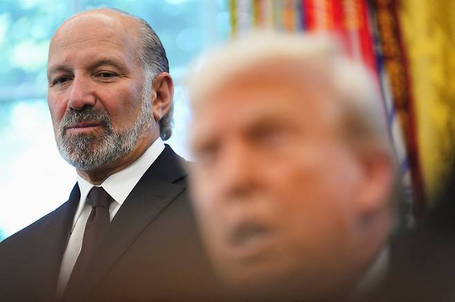 U.S. Secretary of Commerce Howard Lutnick, left, listens as U.S. President Donald Trump speaks in the Oval Office at the White House in Washington on Sept. 19. [REUTERS/YONHAP]