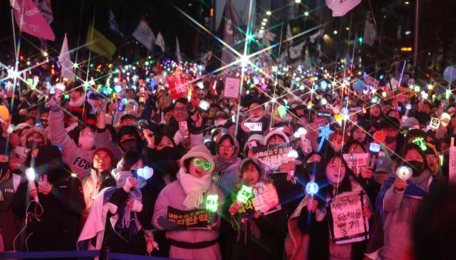 ▲윤석열 대통령 탄핵소추안이 가결된 2024년 12월 14일 서울 여의도 국회 앞에서 열린 탄핵 촉구 집회에 참석한 시민들이 기뻐하며 노래를 따라부르고 있다. ⓒ연합뉴스