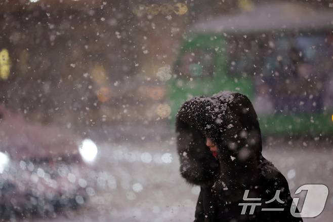 첫눈이 내린 4일 오후 서울 광화문 네거리에서 퇴근길 시민들이 발걸음을 재촉하고 있다. 행정안전부는 이날 서울, 인천, 경기, 강원 등 4개 시도에 '대설 특보'를 발효했다. 2025.12.4/뉴스1 ⓒ News1 황기선 기자