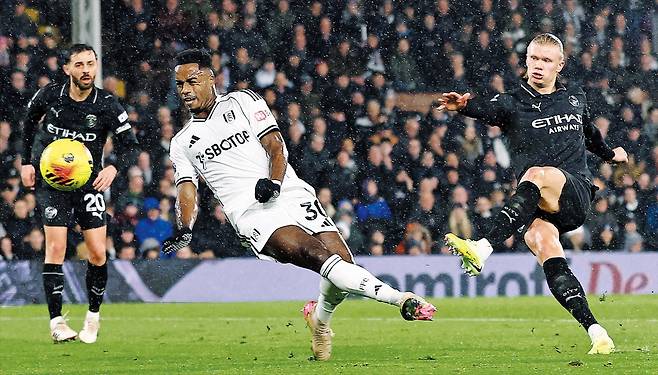 로이터 연합뉴스맨체스터 시티 공격수 엘링 홀란(오른쪽)이 3일(한국 시각) 빗속에서 열린 잉글랜드 프리미어리그 풀럼과의 런던 원정 경기에서 왼발 슈팅으로 선제골을 넣고 있다. 풀럼 수비수 라이언 세세뇽(가운데)이 몸을 날렸지만 슈팅이 빨랐다. 홀란은 이 득점으로 역대 최소인 111경기 만에 프리미어리그 100골을 달성했다.