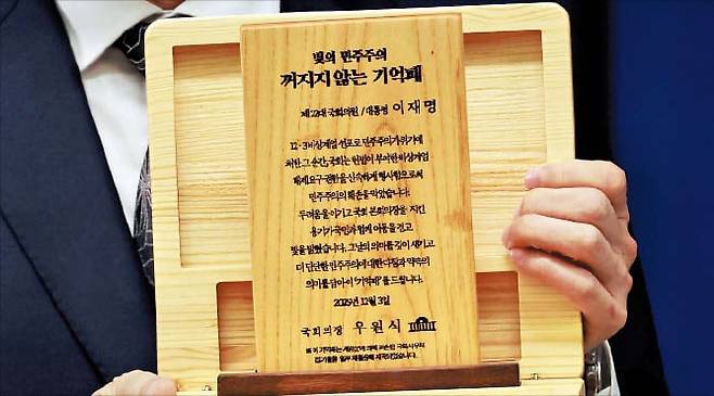 뉴시스계엄 기억패  우원식 국회의장이 이재명 대통령에게 선물한 ‘기억패’. 3일 이규연 대통령실 홍보소통수석이 공개한 이 패는 12·3 비상계엄 당시 파손된 국회사무처 집기로 만들었다.