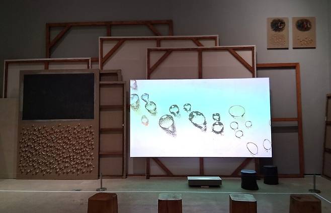 미술관에서 가장 깊은 지하에 있는 7전시실 들머리를 지나면 그의 물방울 화폭들을 뒷모습만 보인 채 쌓아놓은 공간이 펼쳐진다. 이 공간을 배경으로 작가가 물방울 그림을 그려나가는 작업 과정을 보여주는 동영상이 상영되고 있다. 노형석 기자