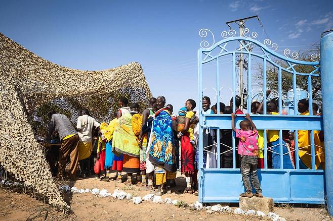 케냐 의회가 2일(현지시간) 케냐 영국군 훈련단(BATUK) 소속 군인들이 저지른 살인·성폭력·폭행 등 범죄와 관련한 보고서를 발표했다. 사진은 지난 7월 케냐 삼부루 카운티의 한 영국·케냐군 합동 임시 진료소 앞에 진료를 받기 위해 줄 서 있는 주민들 모습. AFP연합뉴스