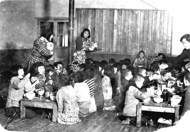 윤학자 여사가 1956년 공생원의 아동들과 함께 식사를 하고 있다. 가장 뒷편에 앉은 인물이 윤학자 여사다.   (c)사회복지법인 공생복지재단