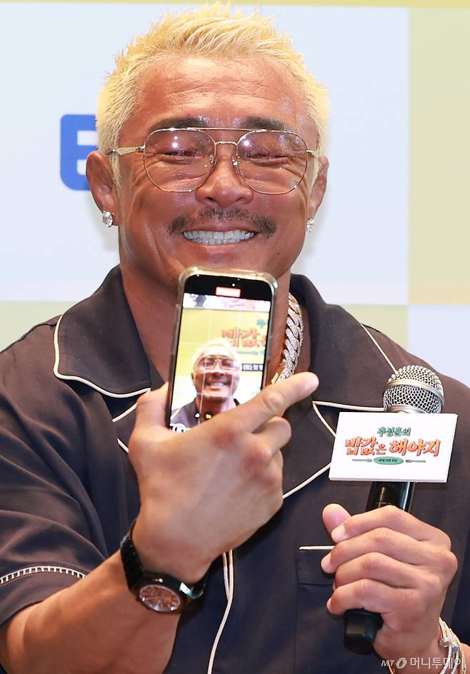 (서울=뉴스1) 권현진 기자 = 격투기 선수 추성훈이 23일 서울 여의도 TWO IFC에서 열린 ENA, EBS 공동제작 '추성훈의 밥값은 해야지' 제작발표회에 참석해 현장을 핸드폰에 담고 있다.   '추성훈의 밥값은 해야지'는 '아조씨' 추성훈이 세계 극한 직업에 도전하고 땀 흘려 번 밥값만큼 즐기는 현지 밀착 리얼 생존 여행기다 2025.7.23/뉴스1  Copyright (C) 뉴스1. All rights reserved. 무단 전재 및 재배포,  AI학습 이용 금지. /사진=(서울=뉴스1) 권현진 기자