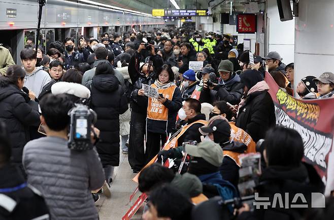 [서울=뉴시스] 이영환 기자 = 4일 오전 서울 종로구 지하철5호선 광화문역에서  '제67차 출근길 지하철 탑니다’ 시위가 진행중인 가운데 출근길 시민들이 이동하고 있다. 2025.12.04. 20hwan@newsis.com