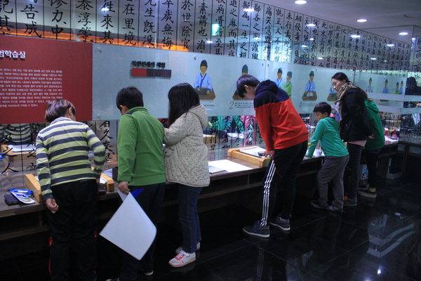 밀양시립박물관에서 목판 인쇄 체험을 하는 학생들.