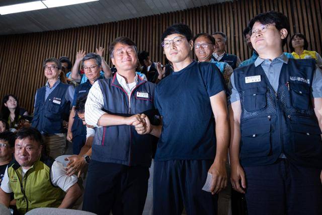 양경수(맨 앞줄 왼쪽) 민주노총 위원장이 지난 8월 24일 서울 여의도 국회에서 노란봉투법이 통과되자 유최안 금속노조 한화오션(옛 대우조선해양) 사내하청지회 조합원의 손을 잡는 모습. 뉴스1