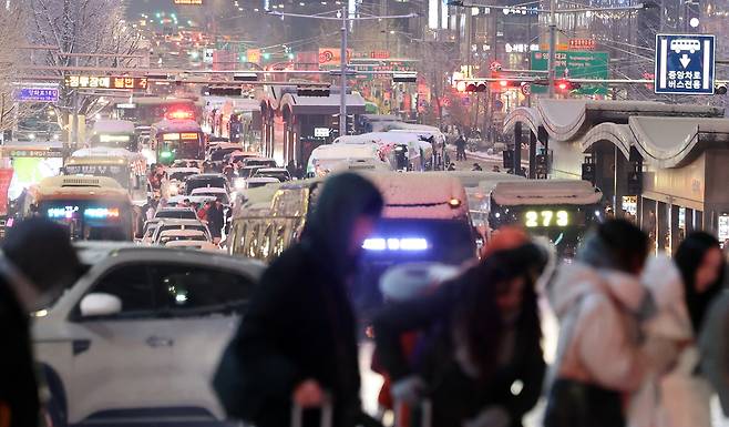 Evening commuters crowd snow-covered streets near Yanghwa-ro in western Seoul on Thursday, as heavy-snow advisories for Seoul, Incheon, Gyeonggi and Gangwon caused severe rush-hour gridlock. (Yonhap)