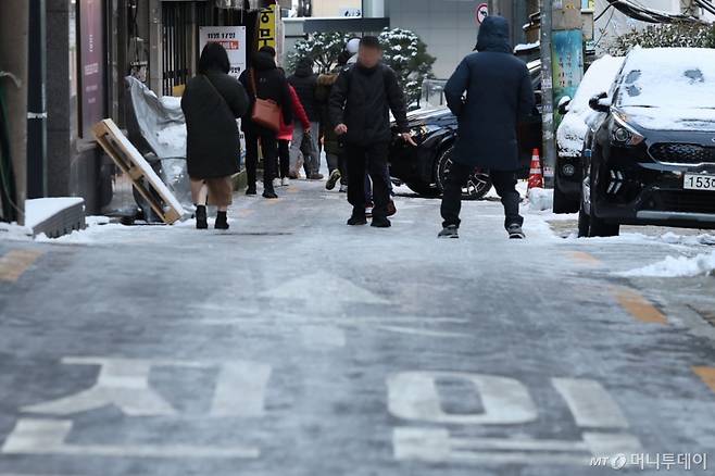 [서울=뉴시스] 권창회 기자 = 폭설 후 한파로 도로 곳곳이 얼어붙은 5일 오전 서울 중구 충무로역 인근에서 시민들이 빙판길을 조심히 걷고 있다. 2025.12.05. kch0523@newsis.com /사진=권창회