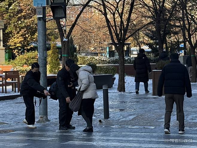 5일 오전 서울 영등포구 여의도 일대 횡단보도에서 한 행인이 급히 뛰다가 넘어져 다른 행인들의 도움을 받고 있다. 전새날 기자.