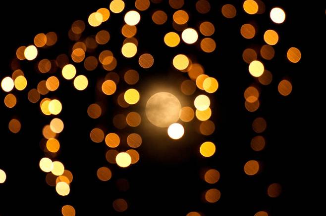 [이스탄불=AP/뉴시스] 4일(현지 시간) 튀르키예 이스탄불의 크리스마스 조명 장식 사이로 올해 마지막 보름달인 슈퍼문이 떠오르고 있다. 2025.12.05.