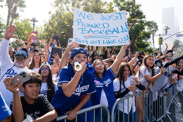 LA 다저스 우승 축하 퍼레이드를 보기 위해 참석한 팬이 ‘우리가 야구를 망쳤다. 쟤들은 우리와 다르다’가 적힌 손팻말을 들어보이고 있다. 게티이미지