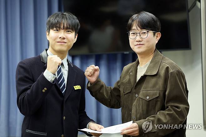 광주 서석고서 2026 수능 만점자 배출 (광주=연합뉴스) 김혜인 기자 = 2026학년도 수능 성적표가 배부되는 5일 광주 서구 화정동 서석고등학교에서 만점자 재학생 최장우군이 정승균 담임교사로부터 성적표를 받으며 기념촬영을 하고 있다. 2025.12.5 in@yna.co.kr