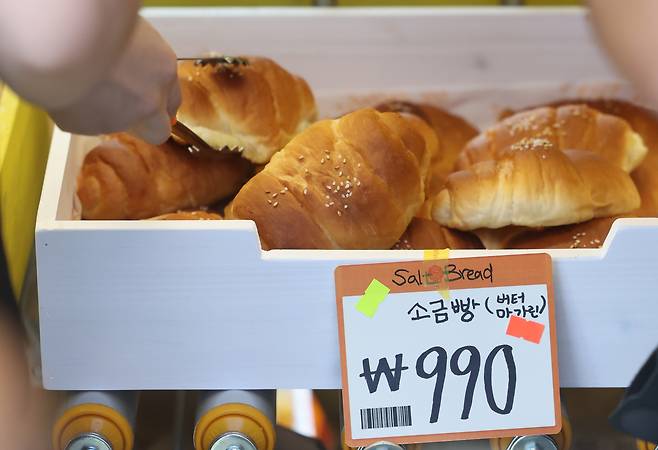 서울 성동구 글로우 성수에 마련된 유튜버 ‘슈카월드’의 베이커리 팝업 스토어 ETF베이커리를 찾은 시민들이 990원에 판매되는 소금빵을 고르고 있다. [뉴시스]