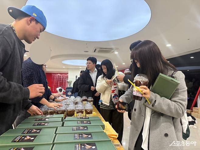 KT 안현민(왼쪽)이 6일 수원KT위즈파크 구내식당에 팬 46명을 초청해 직접 만든 요리를 제공한 뒤, 사비로 구매한 음료와 위즈TV가 준비한 기념 수건을 직접 나눠주고 있다. 사진제공｜KT 위즈