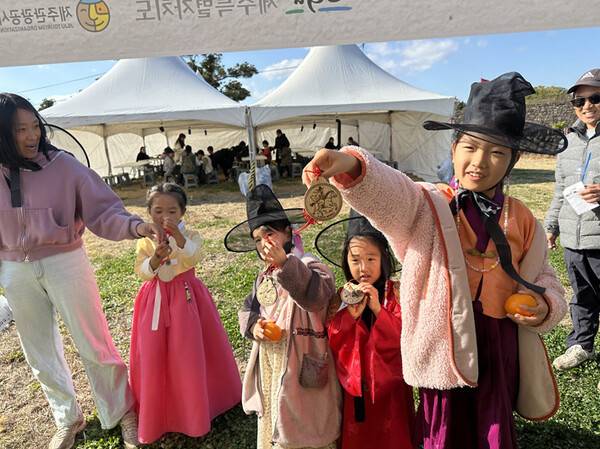 지난 6일 성읍민속마을 일대에서 열린 '오마이갓 제주헌터스' 행사에서 참가 어린들이 마패를 들어보이고 있다. (사진=제주관광공사)
