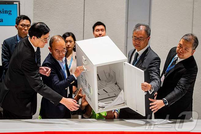 7일 홍콩에서 치러진 입법회 선거 투표 종료 후 첫 번째 투표함을 비우는 관계자들. 2025.12.07.ⓒ AFP=뉴스1