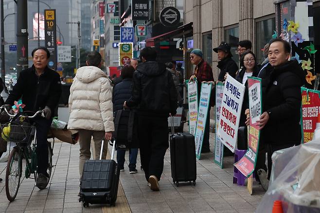 지난달 24일 아침 서울 중구 세종호텔 앞에서 세종문화 투쟁 아침선전전이 열려 팻말을 든 참가자들 앞으로 세종호텔에서 나온 여행객들이 지나가고 있다. 백소아 기자 thanks@hani.co.kr