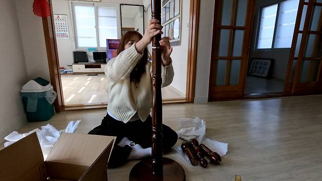 만능배달꾼이 가구거리에서 사 온 행거를 조립하고 있다.