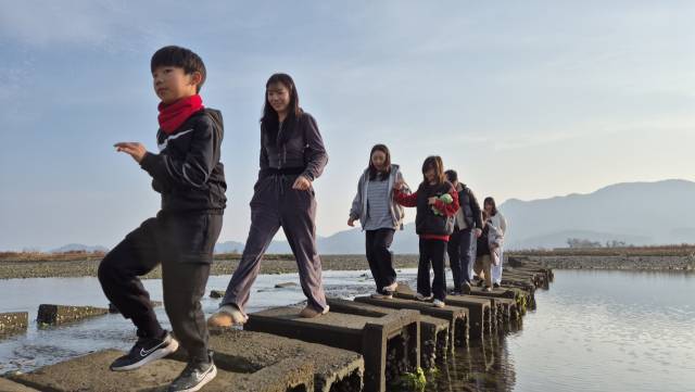 지난 7일 창원시 마산합포구 진전면 율티마을에서 우해이어보 투어 참가자들이 돌다리를 건너고 있다./창시뮤컴퍼니/