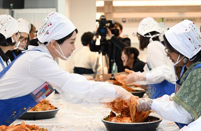 김혜경 여사가 9일 서울 종로구 북촌 한식문화공간에서 열린 주한대사 배우자 초청 김장 행사에서 한 대사 부인의 김장마무리를 도와주고 있다. 왕태석 선임기자