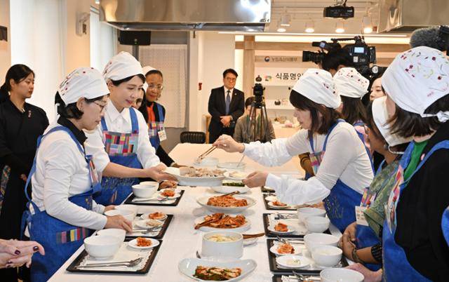 김혜경 여사가 9일 서울 종로구 북촌 한식문화공간에서 열린 주한대사 배우자 초청 김장 행사에서 김장체험을 마치고 김치와 먹을 수육을 나눠주고 있다. 왕태석 선임기자